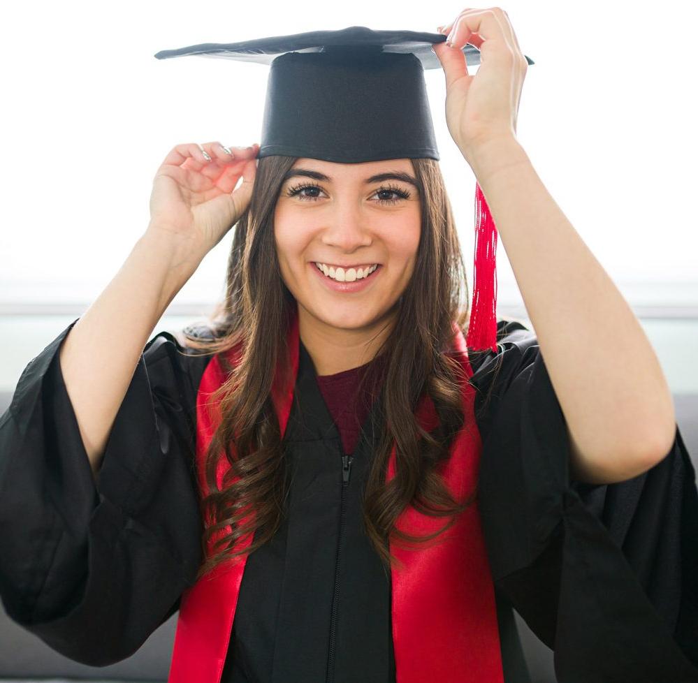 A smiling graduate in cap and gown